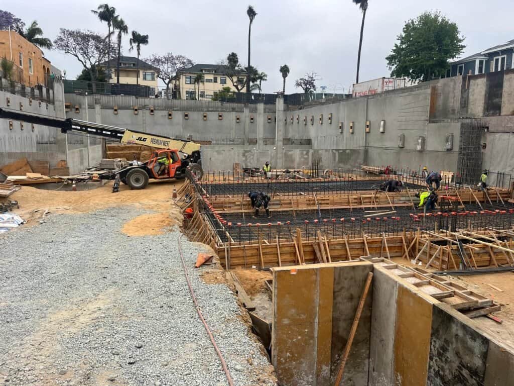 Heavy concrete construction site with rebar and wooden formwork for foundation work.