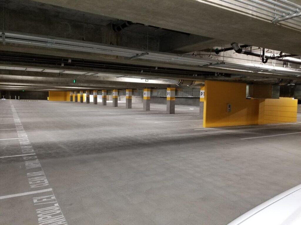 Newly constructed underground parking garage with durable concrete floors and support columns.