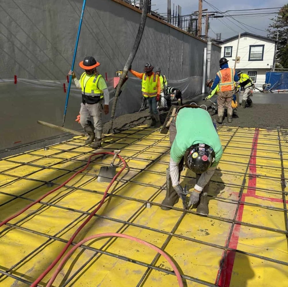 Pouring and finishing concrete for a commercial building foundation with rebar reinforcement.